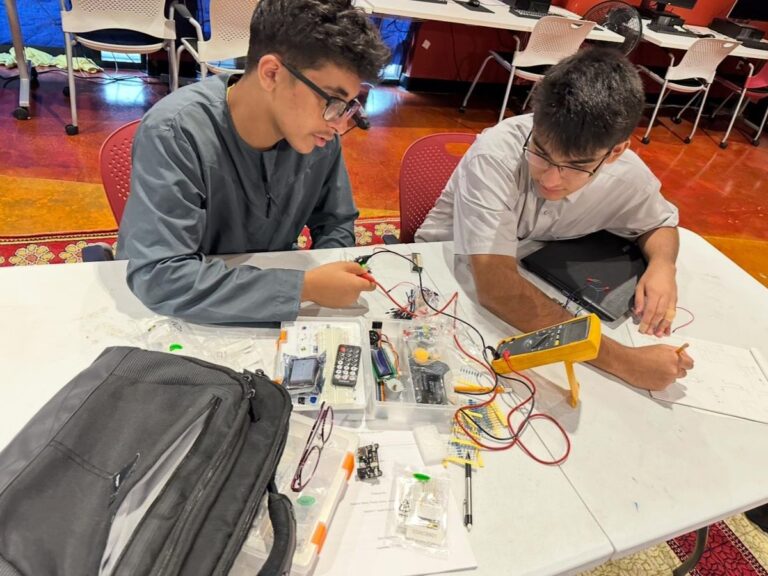 Young Engineers in Action: High school students build and test electronic circuits.
